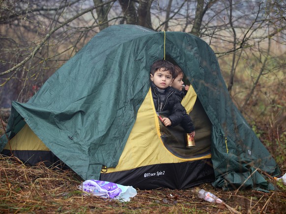 epa09572080 A handout photo made available by Belta news agency shows migrants gathering on the Belarusian-Polish border in the Grodno region, Belarus, 08 November 2021 (issued 09 November 2021). Acco ...