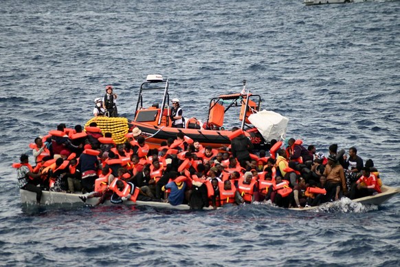 In this photo released by Doctors Without Borders, an overcrowded wooden boat packed with 99 migrants is approached by a tender of the humanitarian organization off the Libya coast on Tuesday, Nov. 16 ...