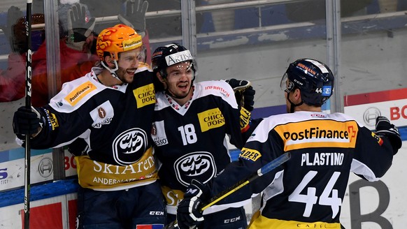 Ambri&#039;s player Bryan Flynn, left, celebrates the goal in the over time with Ambri&#039;s player Noele Trisconi, center, and Ambri&#039;s player Nick Plastino, right, during the preliminary round  ...