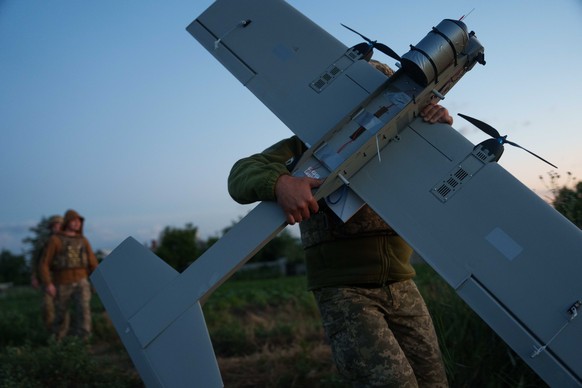 A Ukrainian serviceman of K-2 brigade of the Unmanned Systems Forces carries a midrange drone on takeoff position before flying towards Russian positions at the frontline in Donetsk region, Ukraine, M ...