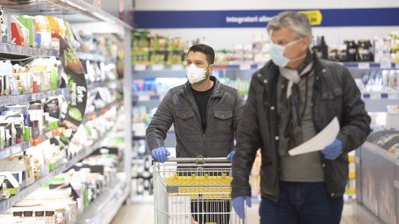 Die Freiwilligenhelfer Adem Salimi, links, und Angelo Vellani, rechts, machen Einkaeufe fuer eine betagte Person, am Montag, 23. Maerz 2020, in Biasca. Aufgrund des Coronavirus verzichten viele aelter ...