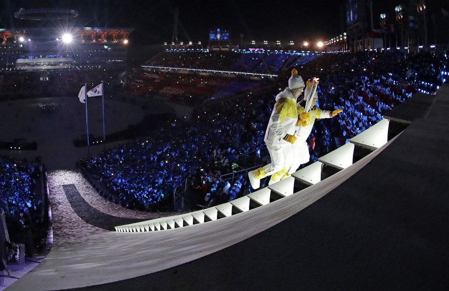 North Korea&#039;s Jong Su Hyon, left, and South Korea&#039;s Park Jong-ah carry the torch during the opening ceremony of the 2018 Winter Olympics in Pyeongchang, South Korea, Friday, Feb. 9, 2018. (A ...