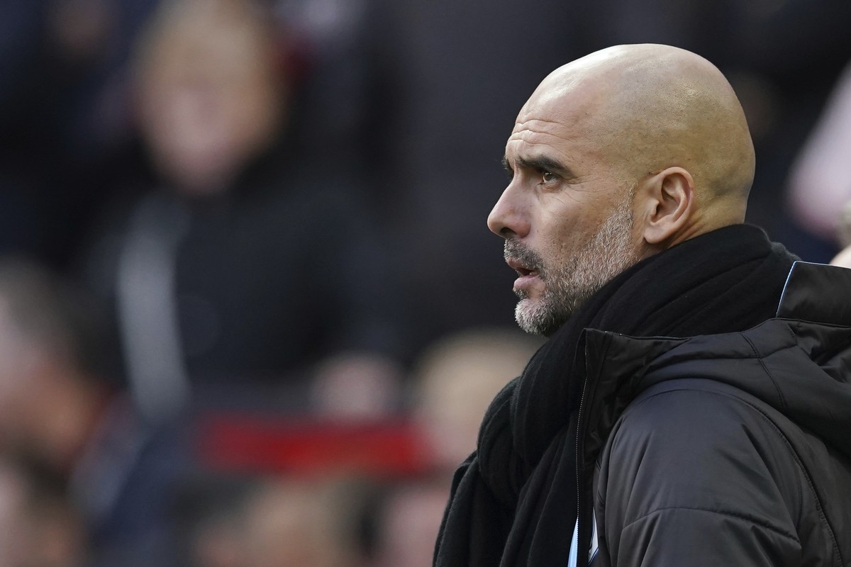 Manchester City's head coach Pep Guardiola watches the English Premier League soccer match between Manchester United and Manchester City at Old Trafford in Manchester, England, Sunday, March 8, 2 ...