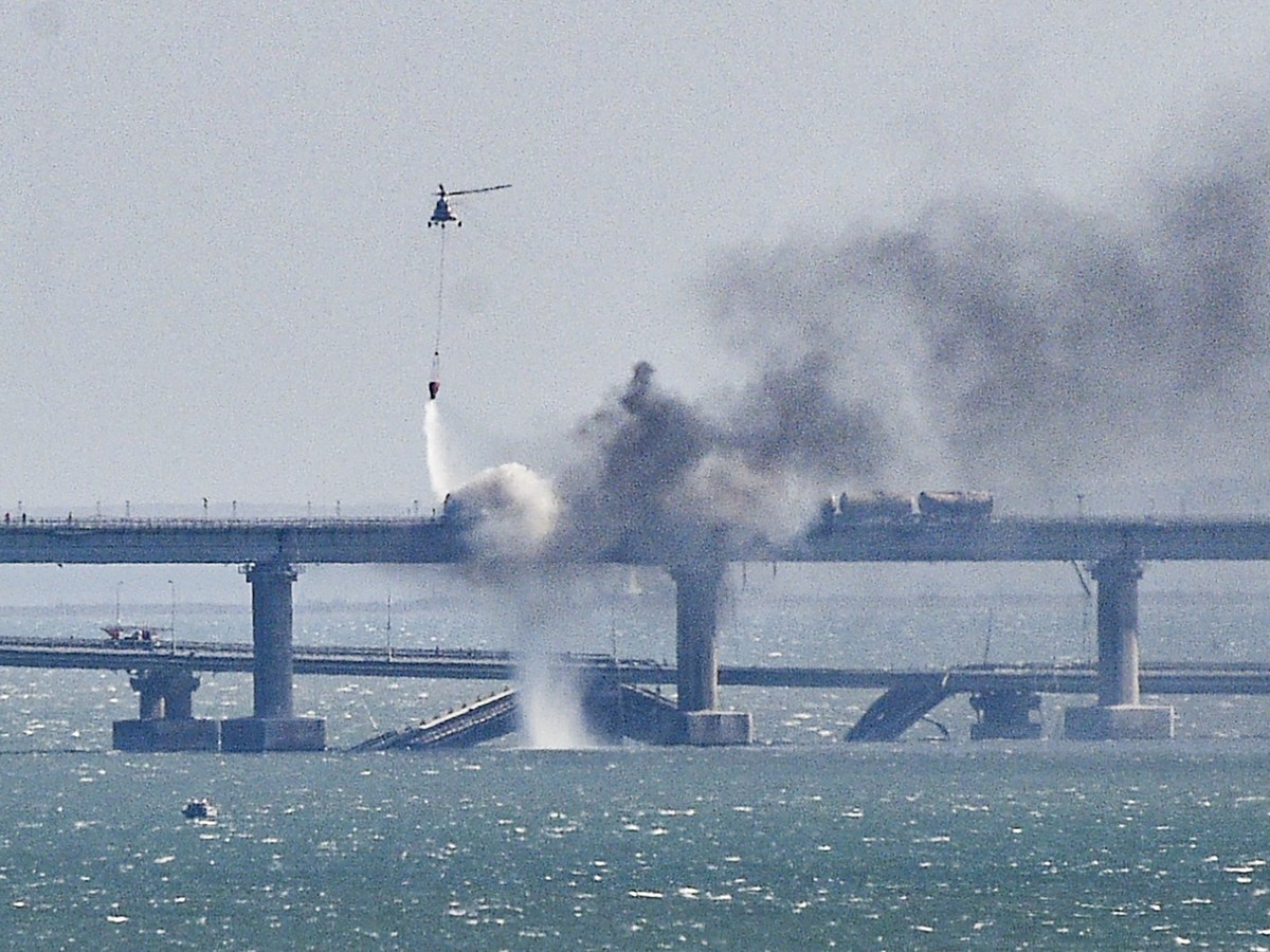 epa10731595 (FILE) - A firefighter helicopter pours water on fire on a collapsed part of the Kerch Strait bridge in Crimea, 08 October 2022. EPA/Stringer