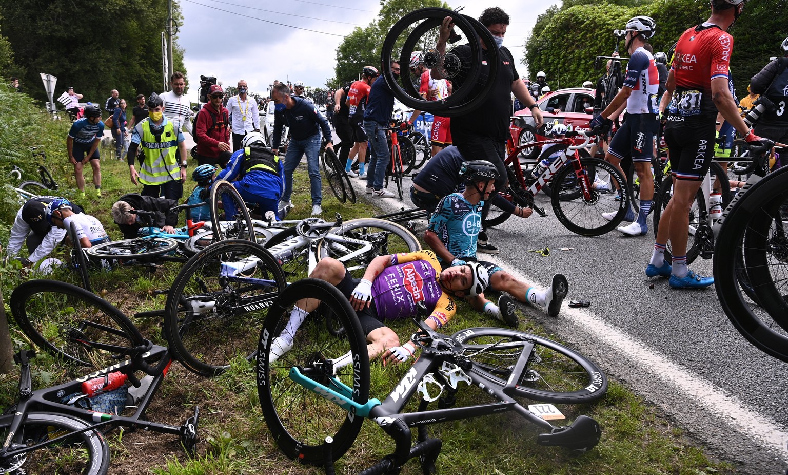 epa09303517 Riders react after a mass crash during the 1st stage of the Tour de France 2021 over 197.8km from Brest to Landerneau, France, 26 June 2021. EPA/Anne-Christine Poujoulat / POOL