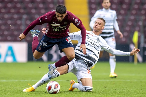 Le joueur du club Balois Jasper van der Werff, droite, lutte pour le ballon avec le joueur du club Genevois Kastriot Imeri, gauche, lors de la rencontre de football de Super League entre le Geneve Ser ...