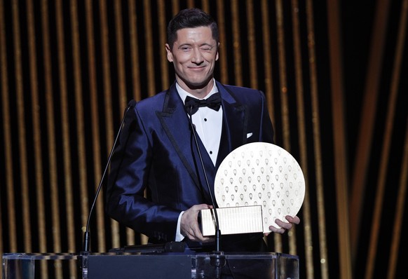 epa09611593 Bayern Munich striker Robert Lewandowski winks after receiving the 2021 Striker of the Year award during the 2021 Ballon d'Or ceremony at Theatre du Chatelet in Paris, France, 29 Nove ...