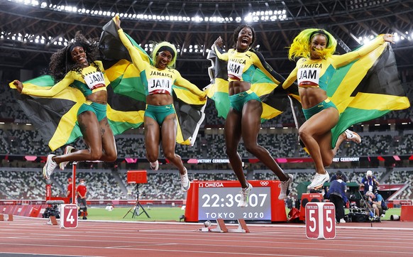 epa09401341 (from left) Elaine Thompson-Herah, Shelly-Ann Fraser-Pryce, Shericka Jackson and Briana Williams of Jamaica celebrate after winning the Women&#039;s 4x100m Relay final of the Athletics eve ...