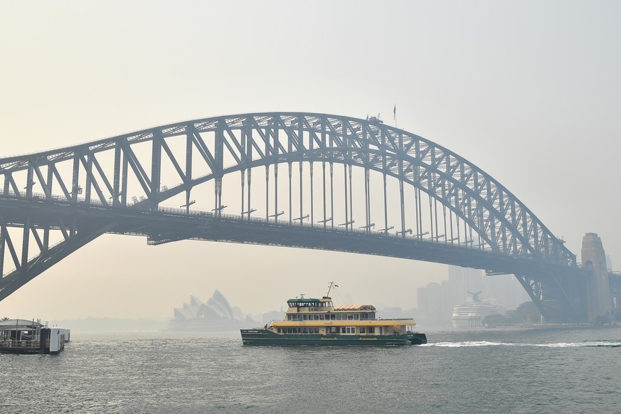 epa08058605 A view of the Sydney Harbour Bridge as smoke and haze from bushfires in New South Wales blankets the CBD in Sydney, Australia, 10 December 2019. The New South Wales environment department  ...