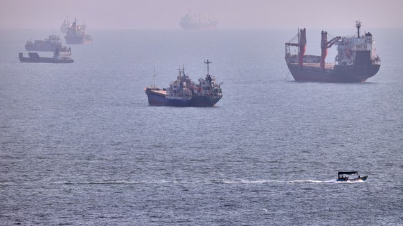 A small boat sails past cargo ships and other commercial vessels anchored in the Strait of Hormuz off Bandar Abbas, Iran, Wednesday, Aug. 5, 2026. (Amirhosein Khorgooi/ISNA via AP)
Iran War Strait of  ...