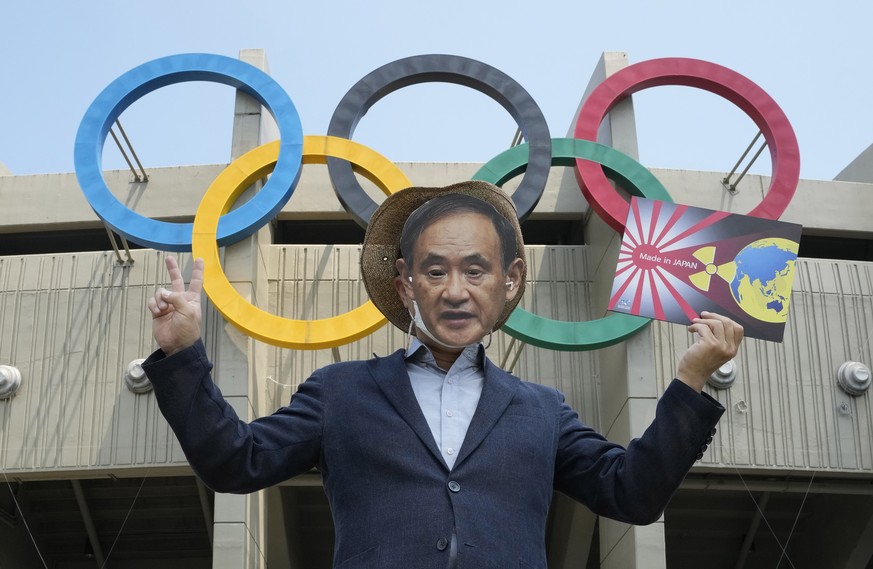 A South Korean environmentalist wearing a mask of Japanese Prime Minister Yoshihide Suga stages a protest against Tokyo 2020 Olympics due to safety concerns against radiation risks, in front of Seoul  ...