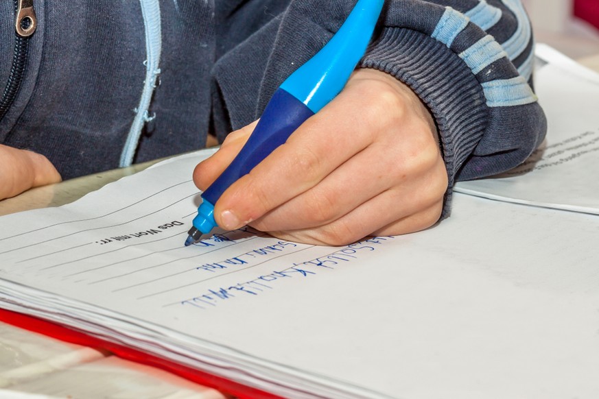 Left-handed person, writing (symbolic image)
