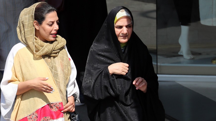 epa10193155 Iranian women walk past in a street, in Tehran, Iran, 19 September 2022. Mahsa Amini, a 22 year old girl, was detained on 13 September by the police unit responsible for enforcing Iran&#03 ...