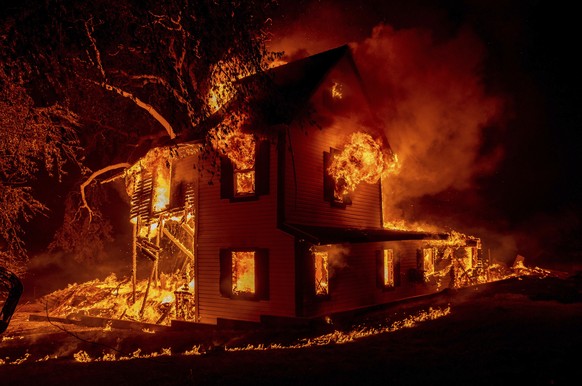 A home is engulfed in flames as the Dixie fire rages south of Janesville in Northern California, on Aug. 16, 2021. (AP Photo/Ethan Swope)