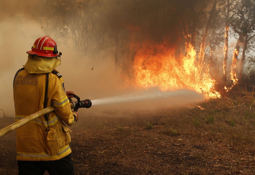 epa07982440 Firefighters work to contain a bushfire along Old Bar road in Old Bar, New South Wales, Australia, 09 November 2019. Two people have been killed and seven others are msising due to bushfir ...