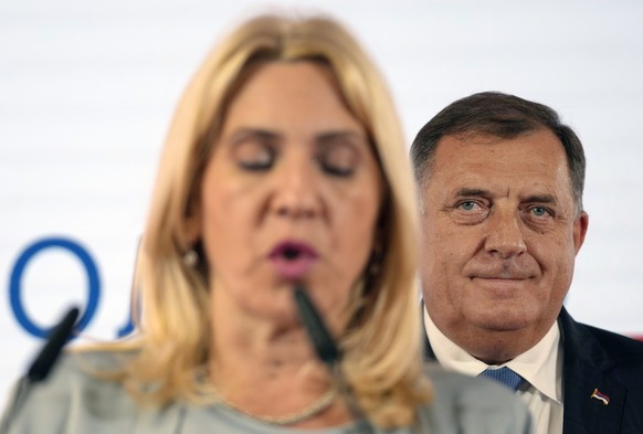 Bosnian Serb leader Milorad Dodik, right, listens as Zeljka Cvijanovic, planned successor for the post of Serbian member of the presidency, speaks during a news conference after claiming victory in a  ...