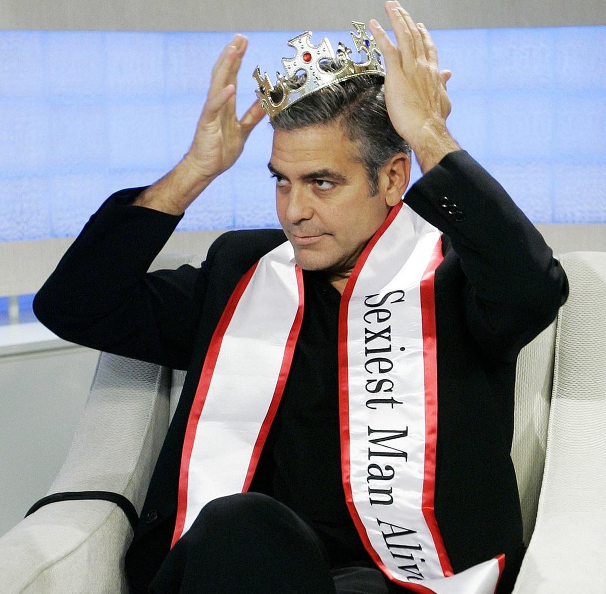 Actor George Clooney puts on a crown and "Sexiest Man Alive" sash presented to him by NBC "Today" television show co-host Matt Lauer, during the taping of an interview, in New York ...