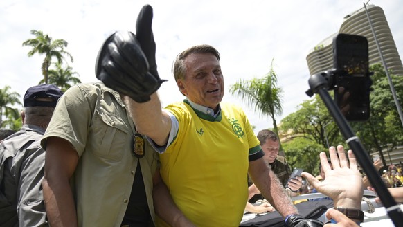 FILE - Brazil&#039;s President Jair Bolsonaro flashes a thumbs up as he greets supporters, wearing a Brazil soccer jersey, as he campaigns in Praca da Liberdade or Liberty Square, in Belo Horizonte, B ...