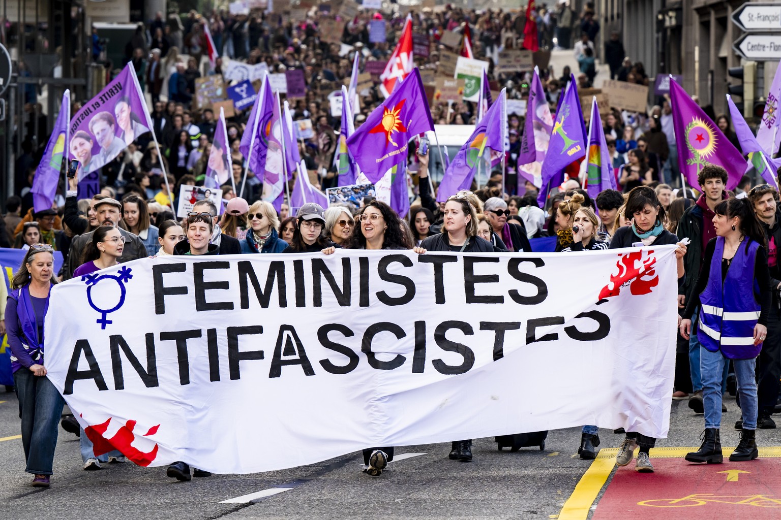 epa11949570 Participants hold a banner and flags during a protest marking the International Women&#039;s Day in Lausanne, Switzerland, 08 March 2025. International Women&#039;s Day is celebrated aroun ...