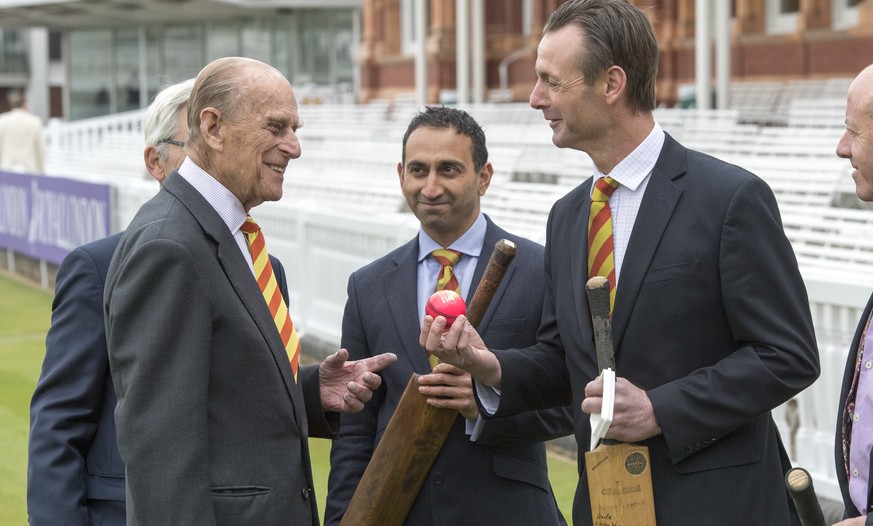 FILE - In this Wednesday, May 3, 2017 file photo former England cricketer John Stephenson, right, shows Britain&#039;s Prince Philip, the Duke of Edinburgh, a pink cricket ball, during his visit to Lo ...