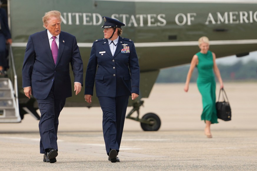 President Donald Trump, left, walks to board Air Force One, followed by White House aide Natalie Harp, background right, Thursday, Aug. 27, 2026, at Joint Base Andrews, Md. (AP Photo/Mark Schiefelbein ...