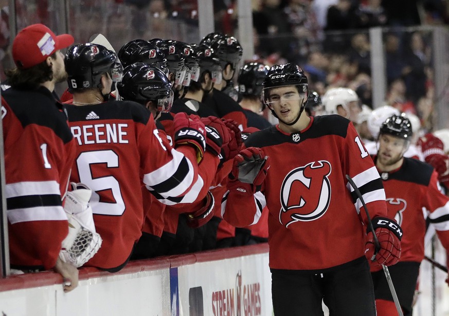 New Jersey Devils center Nico Hischier, right front, of Switzerland, skates by the bench after scoring a goal against the Detroit Red Wings during the first period of an NHL hockey game Wednesday, Dec ...