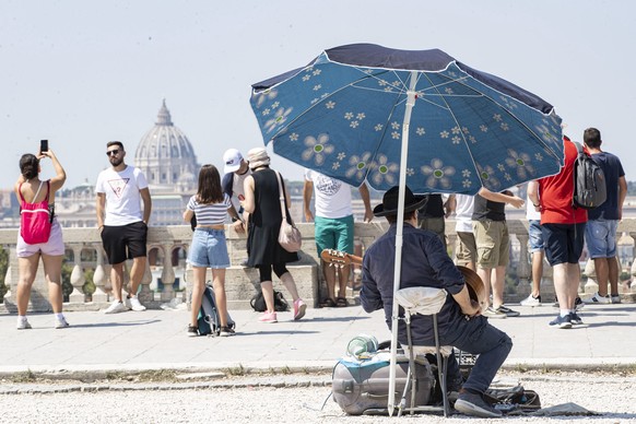 epa09415143 Tourists and residents are seen in Rome, Italy, during Ferragosto, 15 August 2021. Ferragosto is an Italian public holiday celebrated on 15 August every year, coinciding with the major Cat ...