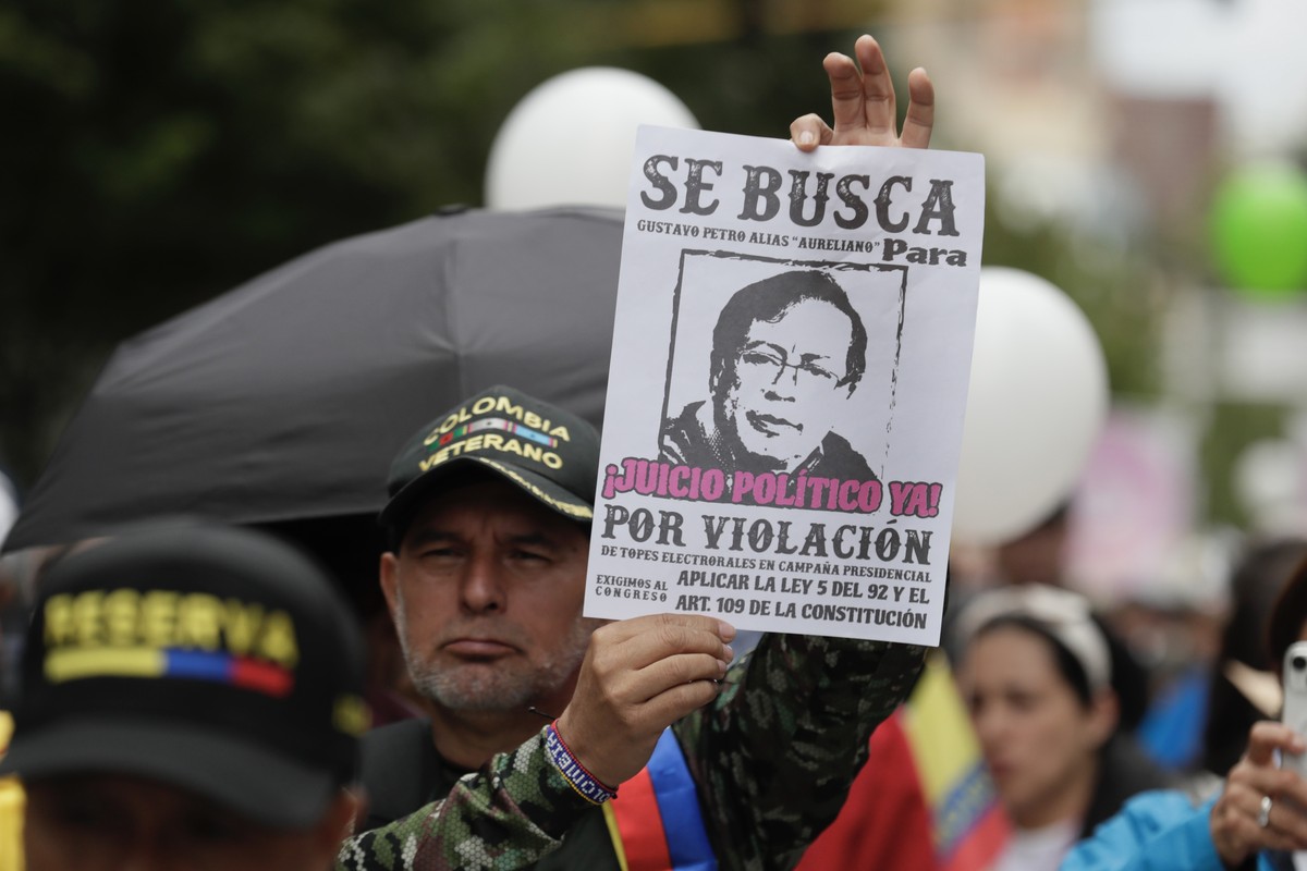 epa11736796 A man hold a placard depicting President Petro with the words 'Wanted for Rape', as people demonstrate during a day of protest against the Government of Gustavo Petro, in Bogota, ...