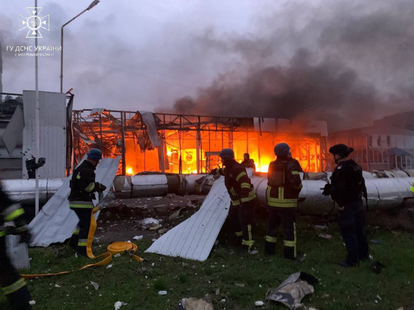 Ukrainische Feuerwehrleute löschen einen Brand nach einem Raketenschlag auf die Stadt Saporischschja.