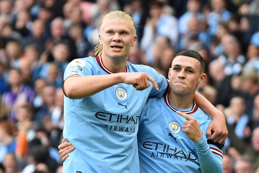epa10219606 Phil Foden (R) of Manchester City celebrates with Erling Haaland (L) after scoring a hat-trick in the English Premier League soccer match between Manchester City and Manchester United at E ...