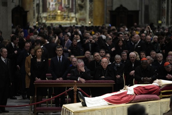 Former Queen of Spain Sofia, left, flanked by Spanish Minister of the Presidency, Felix Bolanos, looks at the body of late Pope Emeritus Benedict XVI, his head resting on a pair of crimson pillows, li ...