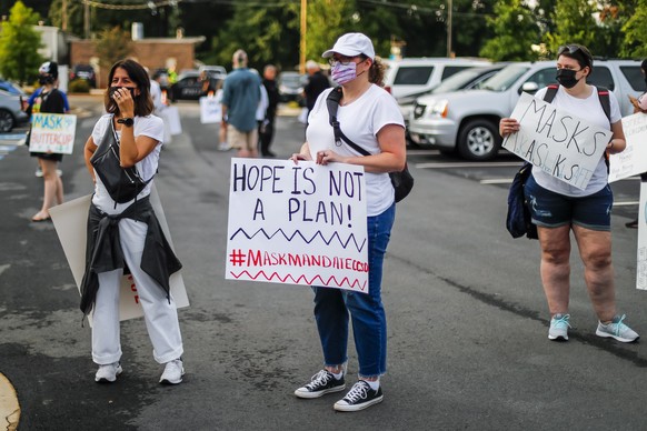 epa09421441 Pro-mask families demonstrate outside a meeting of the school board of the Cobb County School District in Marietta, Georgia, USA, 19 August 2021. Mask proponents want the school board to c ...