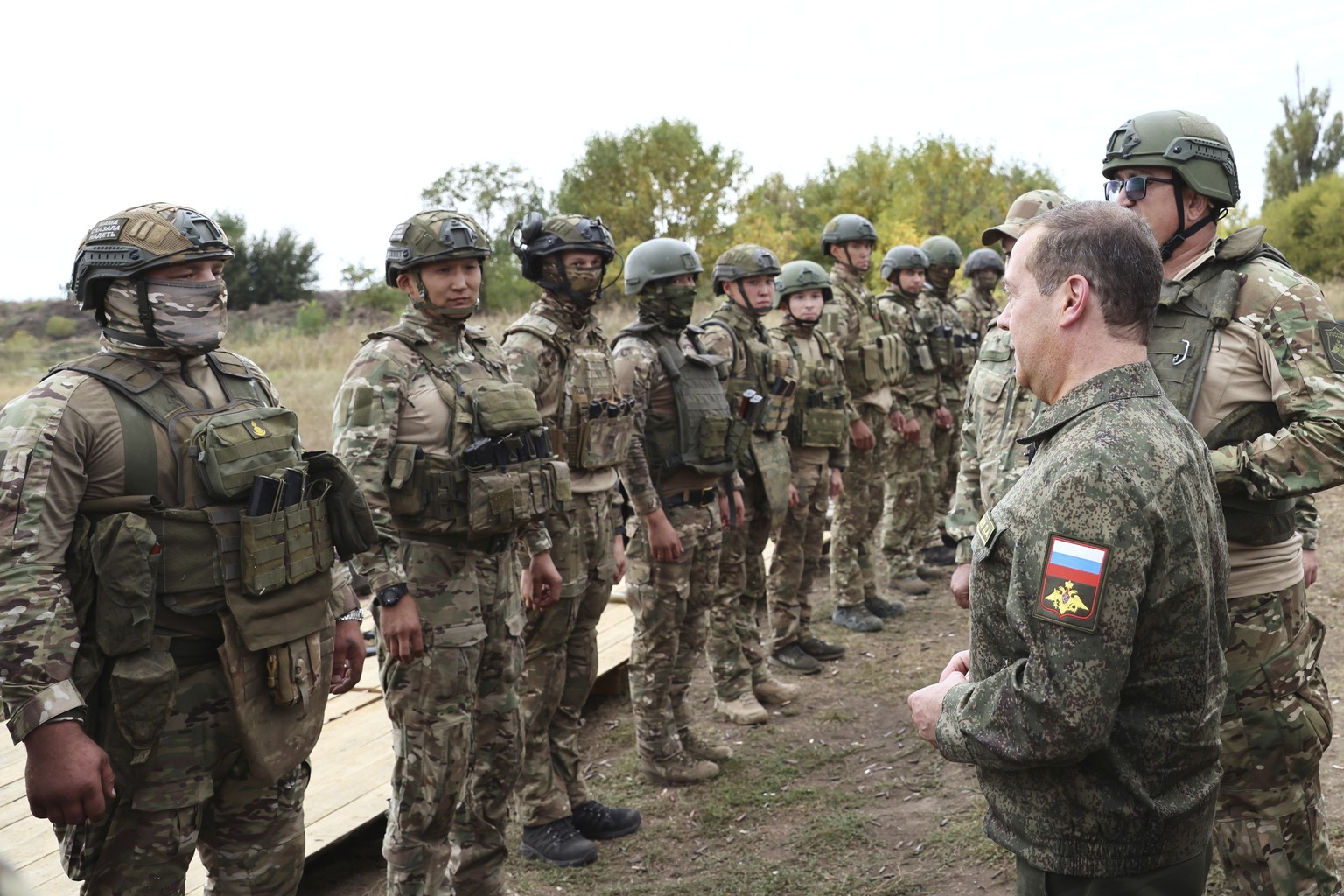 Russian Security Council Deputy Chairman and the head of the United Russia part,y Dmitry Medvedev, front right, speaks to Russian servicemen during his visit at a military training range for contract  ...