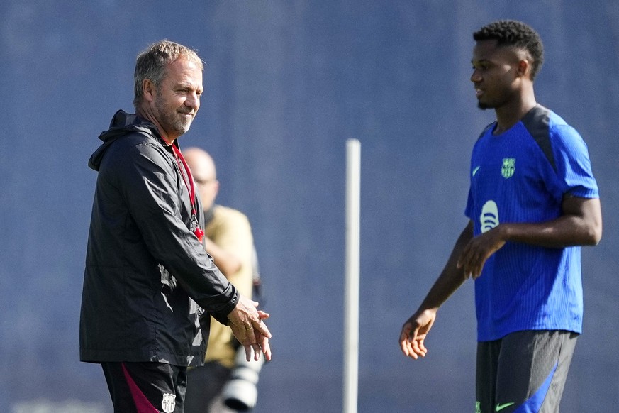 epa11633566 FC Barcelona&#039;s strike Ansu Fati (R) and German head coach Hansi Flick (L) attend the training of the team held at Joan Gamper Sports City in Barcelona, Spain, 30 September 2024. FC Ba ...