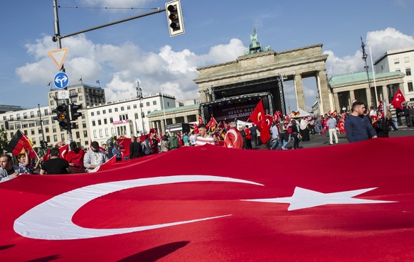 epa05340927 People hold a giant Turkish flag during a protest in Berlin, Germany, 01 June 2016. Some 1,000 people protested in solidarity with Turkey against the German parliament Bundestag&#039;s pla ...