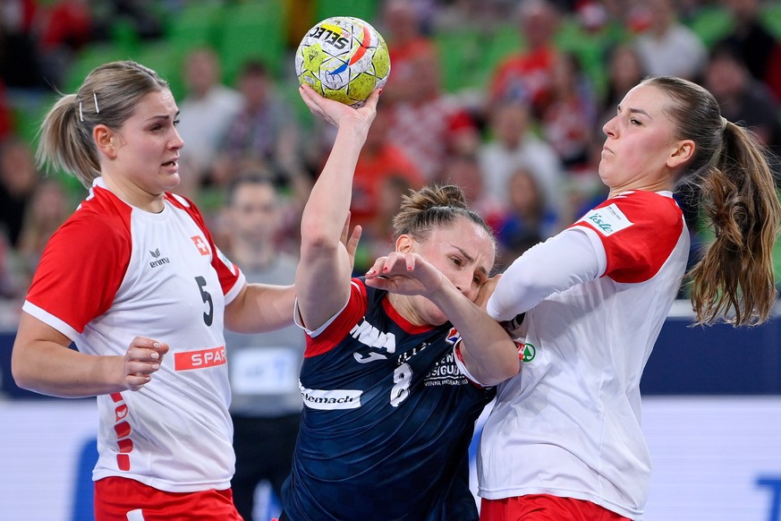 epa10294365 Stela Posavec (C) of Croatia is challenged by Lisa Frey (L) and Xenia Hodel (R) of Switzerland for the ball during the group A match between Croatia and Switzerland in the Women EHF EURO 2 ...