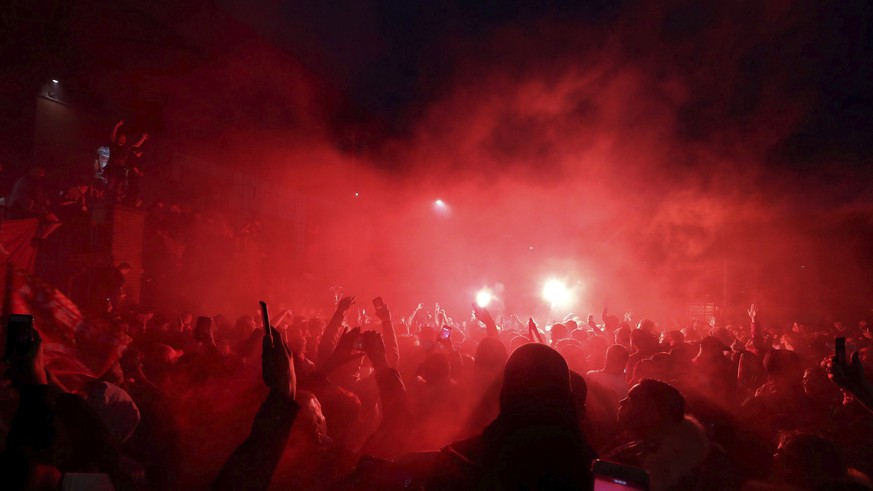 Liverpool fans celebrate outside Anfield stadium after the English Premier soccer match between Liverpool and Chelsea, Wednesday, July 22, 2020, in Liverpool, England. (Martin Rickett/PA via AP)