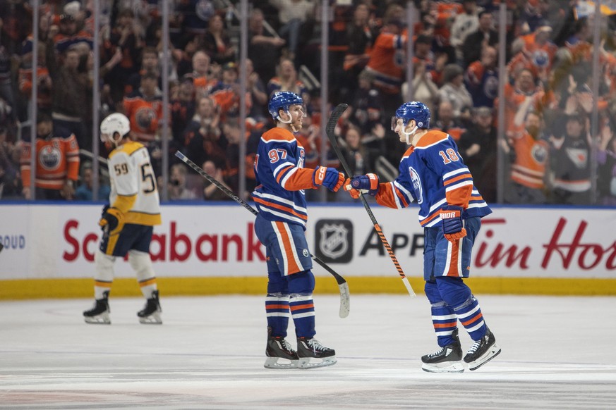 Nashville Predators&#039; Roman Josi (59) skates off as Edmonton Oilers&#039; Connor McDavid (97) and Zach Hyman (18) celebrate after Hyman&#039;s goal during third-period NHL hockey game action in Ed ...