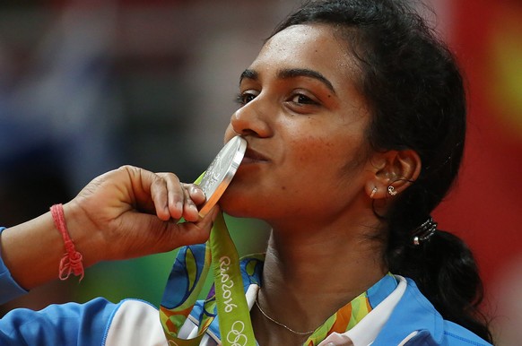 epa05499289 Sindhu Pusarla V. of India celebrates her silver medal on the medal stand after the Rio 2016 Olympic Games Women&#039;s Badminton Singles at the Riocentro in Rio de Janeiro, Brazil, 19 Aug ...