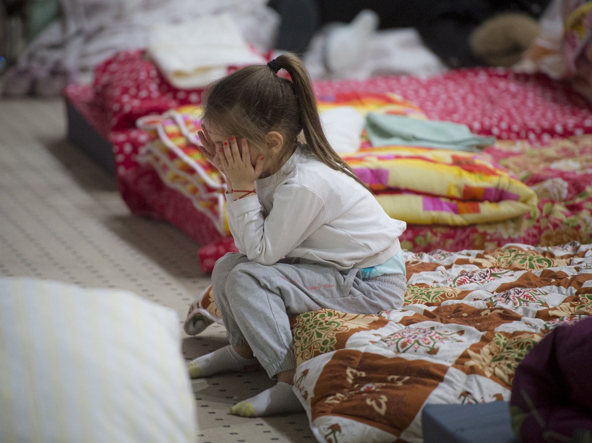 A child refugee who fled the conflict from neighbouring Ukraine covers her face in the event hall of a hotel offering shelter in Siret, Romania, Saturday, Feb. 26, 2022. Romania, which shares around 6 ...