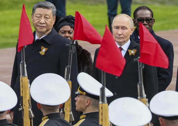 Chinese President Xi Jinping, left, Russian President Vladimir Putin attend a wreath laying ceremony at the Tomb of the Unknown Soldier in Alexander Garden after the Victory Day military parade in Mos ...