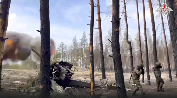 In this handout photo taken from video and released by Russian Defense Ministry Press Service on Wednesday, March 29, 2023, Russian paratroopers fire with the gun-howitzer D-20 toward Ukrainian positi ...