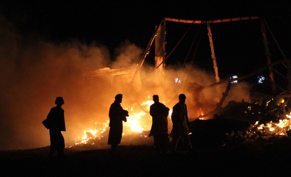 epa09012336 People survey the scene of a fire at Islam Qala Border near Iran, in Herat, Afghanistan, 13 February 2021 (issued 14 February 2021). A fire erupted near the Iranian border in Islam qala ar ...