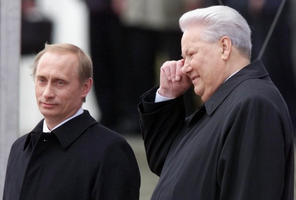 Russian President Vladimir Putin (left) and former President Boris Yeltsin watch as Kremlin guards march into the Moscow Kremlin on May 7, 2000.  In his first public critique of the man he promoted to…