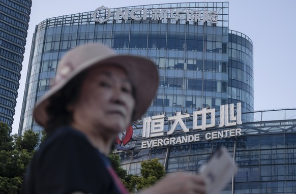 epa09479218 A woman walks past the Evergrande Center in Shanghai, China, 21 September 2021. Evergrande Group is China?s real estate conglomerate and the world?s most indebted property developer. Stock ...