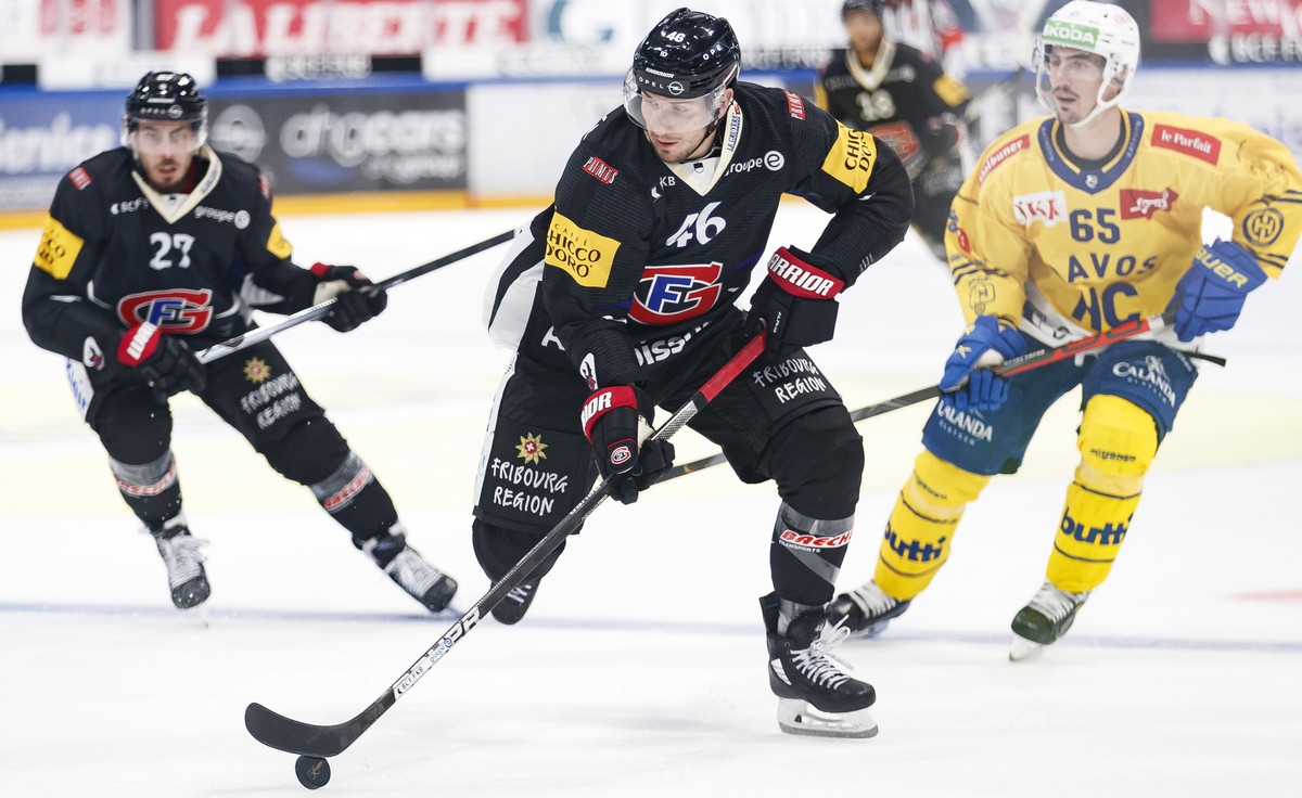L'attaquant fribourgeois Yannick Herren, gauche, l'attaquant fribourgeois Matthias Rossi, centre, lutte pour le puck avec l'attaquant davosien Marc Wieser, droite, lors du match du cham ...