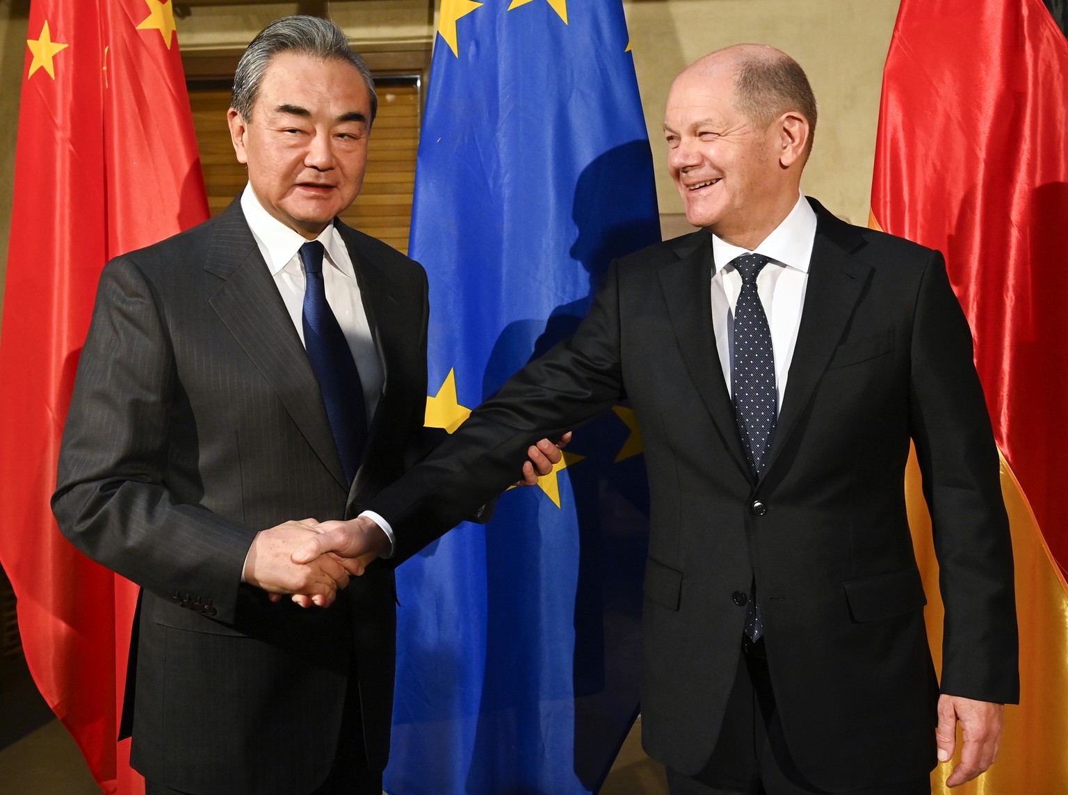 German Chancellor Olaf Scholz, right, shake hands with China&#039;s Director of the Office of the Central Foreign Affairs Commission Wang Yi at the Munich Security Conference in Munich, Germany, Frida ...