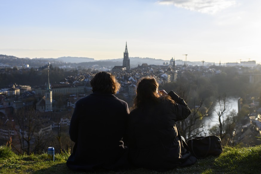 People enjoy the view of the City of Bern during a beautiful afternoon in springtime from Rosengarten, Bern, Switzerland, Saturday, April 3, 2021. (KEYSTONE/Anthony Anex)