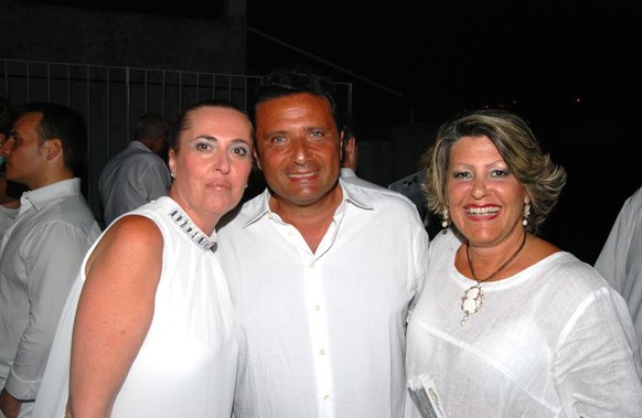 HANDOUT - Handout photo released by Gaetano Ferrandino of italian newspaper &#039;Il Golfo&#039; on 22 July 2014 shows former captain Francesco Schettino (R) with unidentified friends during a party i ...