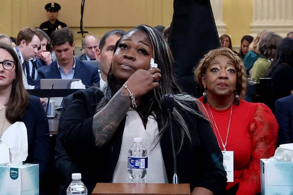 epa10026550 Georgia election worker Shaye Moss (C), gestures while testifying, as her mother, Georgia election worker Ruby Freeman (R), looks on, during a public hearing of the House Select Committee  ...